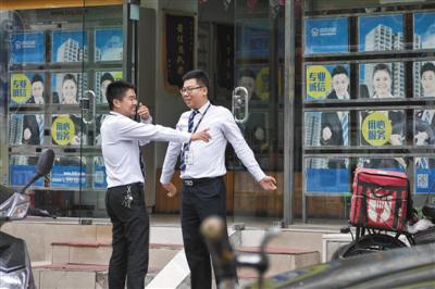 6月12日，方庄，一房屋中介公司门店外，中介人员在聊天。新京报记者 王嘉宁摄