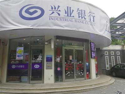 这家社区银行屏幕上打着邮票、生肖金钞等广告。  
